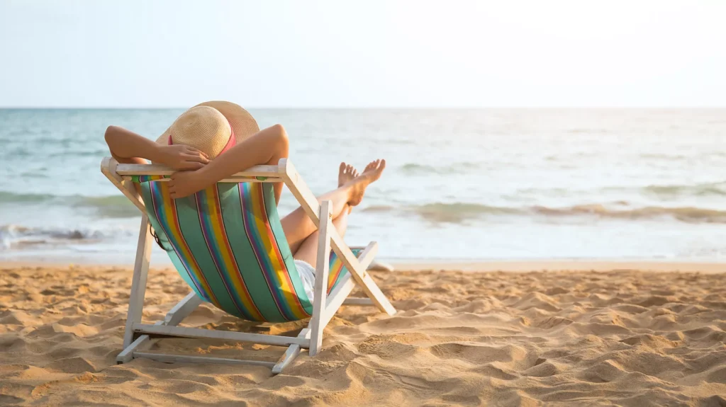 Imagem atual: pessoa repousa em cadeira de praia de frente para o mar. Foto: Peera/Adobe Stock